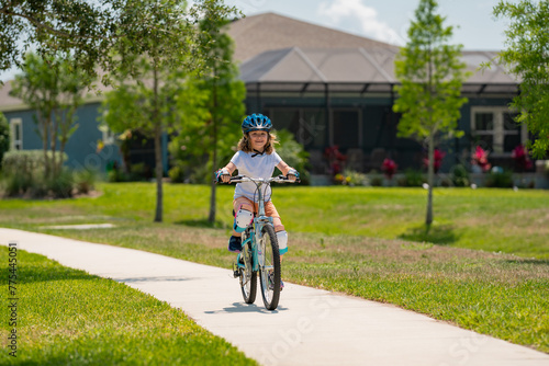 Little kid boy riding a bike in summer park. Children learning to drive a bicycle on a driveway outside. Kid riding bikes in the city wearing helmets as protective gear. Child on bicycle outdoor.