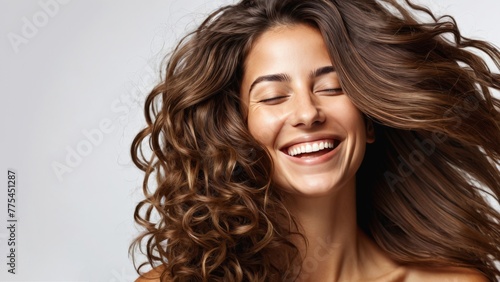 Portrait of a smiling girl with flowing hair on a light background