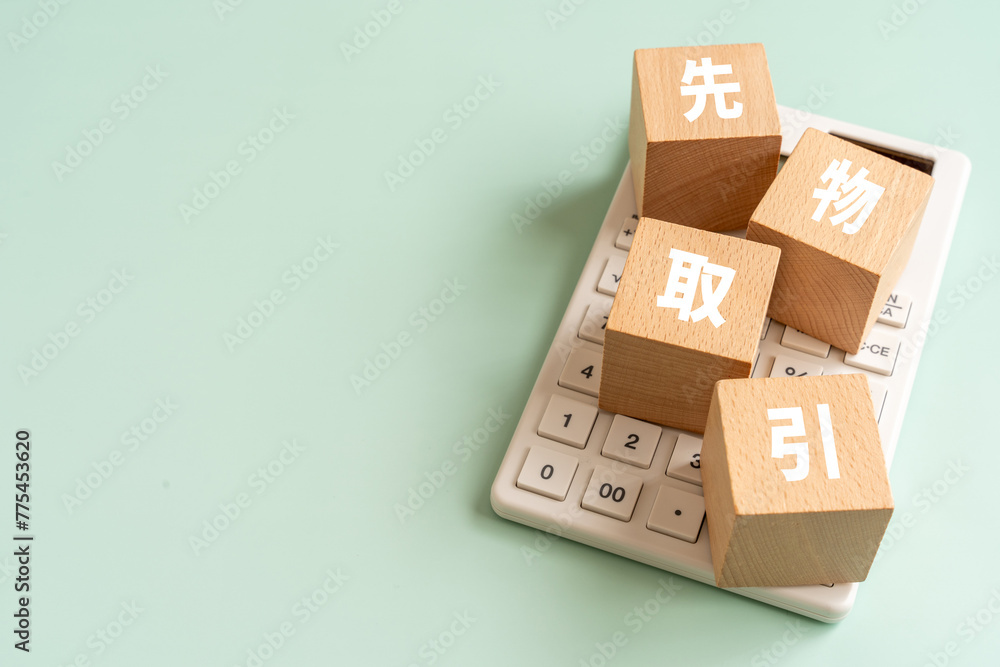 Obraz premium 先物取引と書かれたブロックと電卓