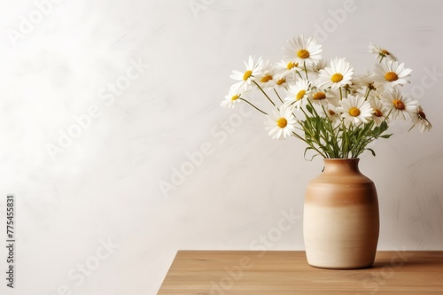 Bouquet of chamomile flowers in vase on wooden table