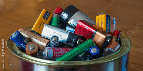 A tin can filled with household batteries. 