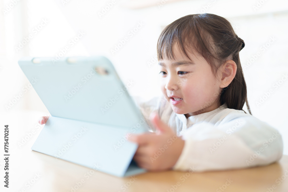 リビングでタブレットを使う女の子 リビングでタブレットを使う女の子