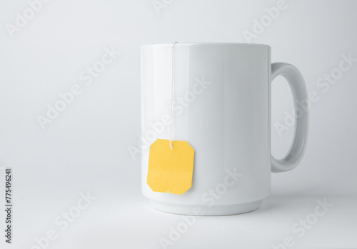 White ceramic mug with teabag label isolated on a white background