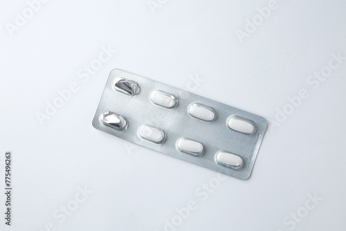 Pills in silver shiny package isolated on white background