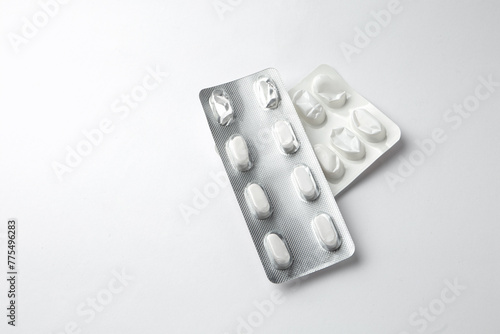 Pills in silver shiny package isolated on white background