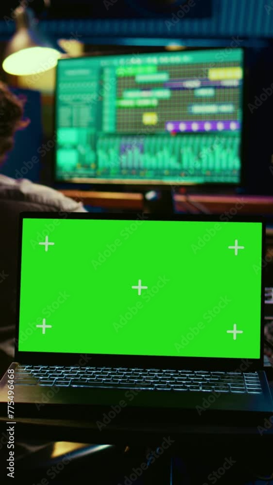 Vertical Video Sound designer and singer look at laptop with isolated display in control room, operating mixing console and volume level buttons to create a hit song. Artist working with audio expert Vertical Video Sound designer and singer look at laptop with isolated display in control room, operating mixing console and volume level buttons to create a hit song. Artist working with audio expert