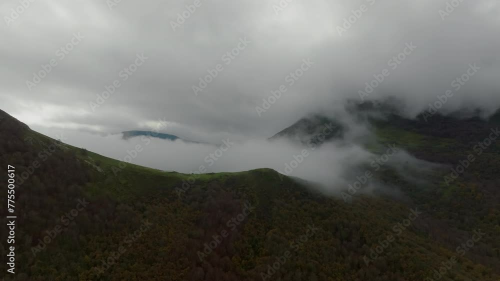 Drone advances through mist revealing the green slopes and valleys of the Basque Country, with the mountain tops shrouded in clouds Drone advances through mist revealing the green slopes and valleys of the Basque Country, with the mountain tops shrouded in clouds