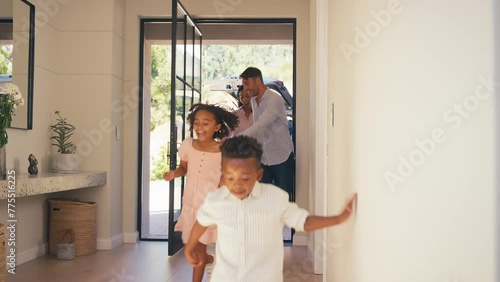 Excited multi racial family with luggage arriving for holiday in house or apartment hugging together - shot in slow motion photo