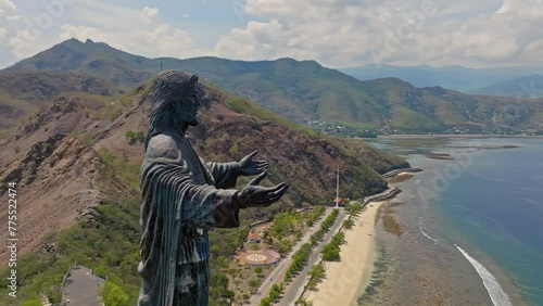 Closeup Of Cristo Rei of Dili Statue And The Beaches In Cape Fatucama, Dili, East Timor. - aerial shot photo