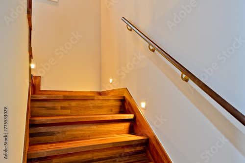 Beautiful bright colored wooden colored stairs that are clean and well lit