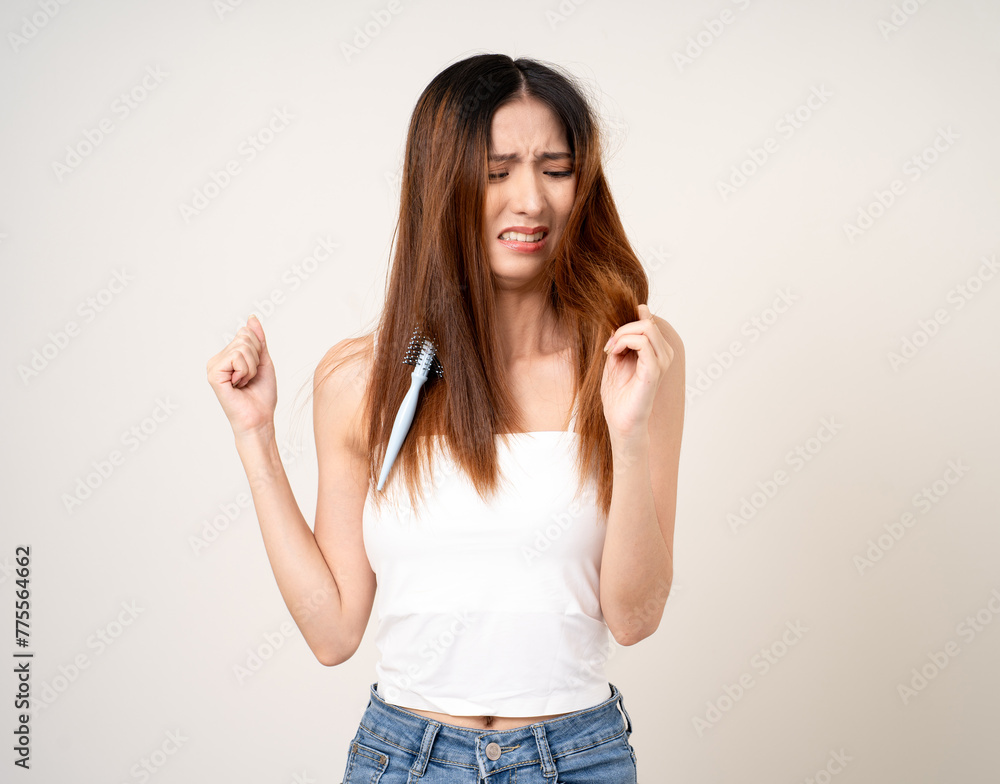 Young asian woman having problems with her hair Thin damaged dry hair falls out easily and is not healthy have to cut off. Standing on isolated white background Young asian woman having problems with her hair Thin damaged dry hair falls out easily and is not healthy have to cut off. Standing on isolated white background