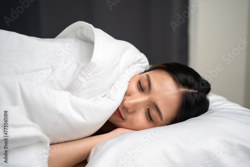 Beautiful asian woman lying in the bed in the night. Young woman sleeping well in comfortable cozy fresh bed on soft pillow white linen. Health and rest concept.