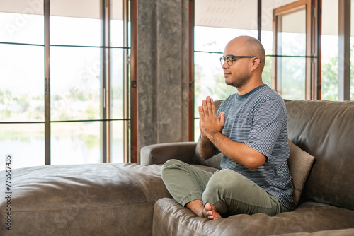 Asian man is meditation feel refreshed and relaxed on sofa in living room. Great pleasure handsome calm man comfortable in the house.