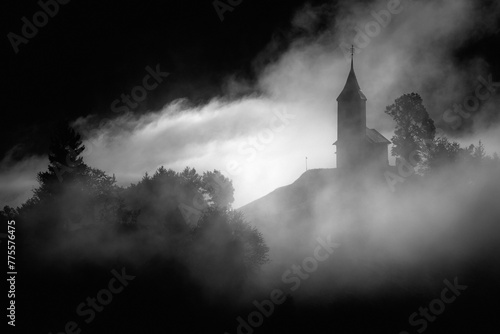 Jamnik, Slovenia - Magical foggy golden summer sunrise at Jamnik St.Primoz church. photo