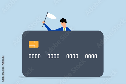 Credit card debt compromise,  bankrupt man surrenders his position and waves the white flag behind large credit card debt.
