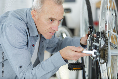 senior man repairing bicycle at home