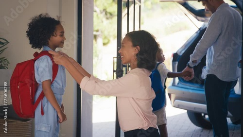 Family at home with parents getting children ready to leave house and go to school