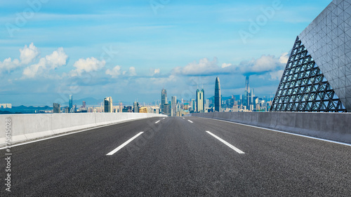 Straight asphalt highway road and glass wall with city skyline in Shenzhen. panoramic view.