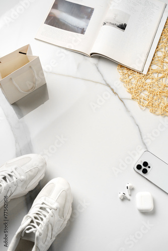 Flat lay composition with sneakers, smartphone and magazine on white background