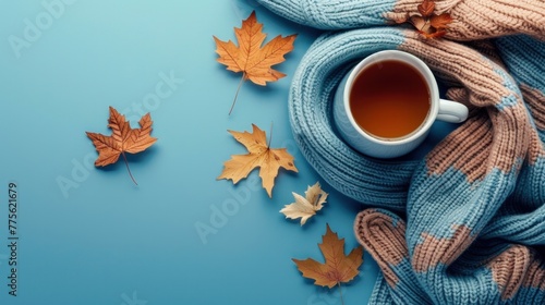 Autumn background on blue. Knitted sweater, mug of hot tea