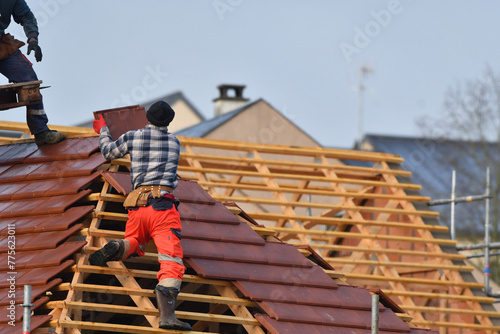 ouvrier couvreur sur un toit d'habitation  photo