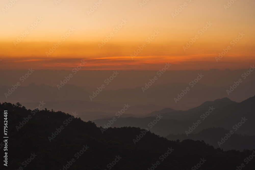 nature traveling with orange sky and layer of mountain with sunrise background