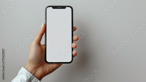 A beautiful hand displaying a modern smartphone with a blank white screen, isolated on a clean, white background for a minimalistic design..
