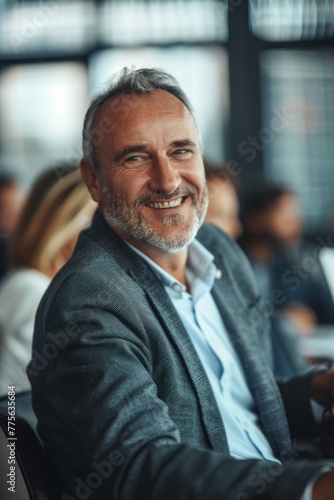 Smiling mature businessman sitting at office with happy colleagues executive team.