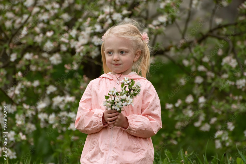 Portrait of thinkful little caucasian girl with spring floral garden in sunny day with flowering branch. Portrait of thinkful little caucasian girl with spring floral garden in sunny day with flowering branch.