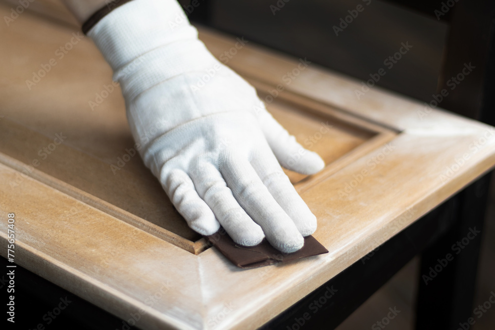 Person remonier worker sands a wooden product, kitchen facade with a sandpaper