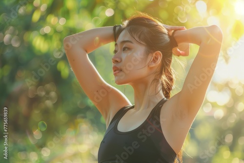 Young woman tying her hair before exercise in the park