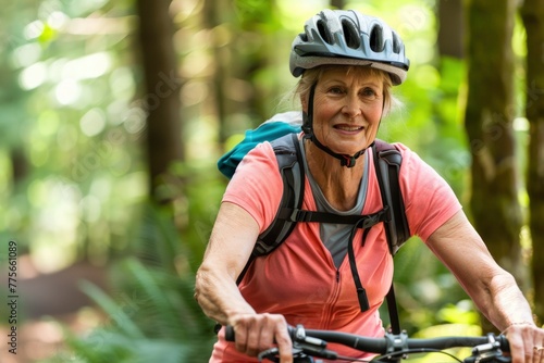 Active senior woman cycling through the forest, wearing a helmet and a bright smile, enjoying nature