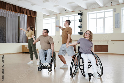 Modern wheelchair dance team having rehearsal in spacious studio, long shot, copy space