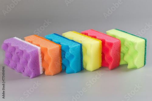 Multi colored synthetic cleaning sponges on a gray background
