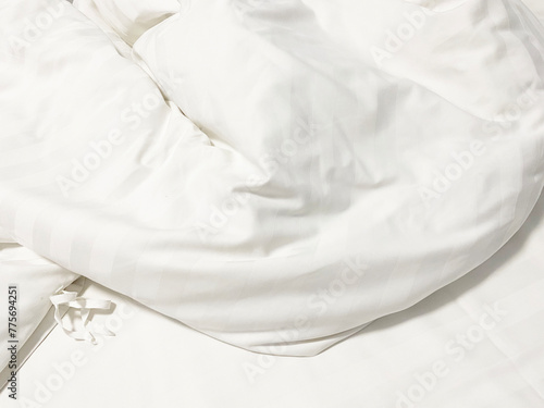 Unmade bed; wrinkled pillowcases, bed sheet and duvet