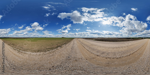 hdri 360 panorama on gravel road among fields in spring evening with awesome clouds in equirectangular full seamless spherical projection, for VR AR virtual reality content