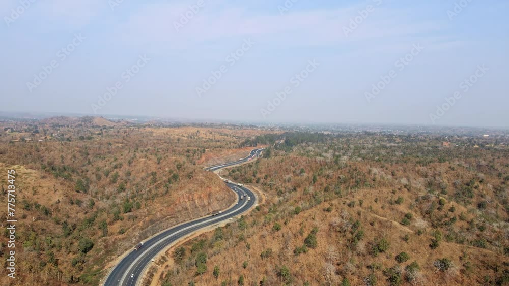 Aerial View of Scenic Indian Highway Amidst Mountainous Terrain. Perfect for illustrating concepts of travel, adventure, infrastructure, and natural beauty. Developing India concept. Aerial View of Scenic Indian Highway Amidst Mountainous Terrain. Perfect for illustrating concepts of travel, adventure, infrastructure, and natural beauty. Developing India concept.