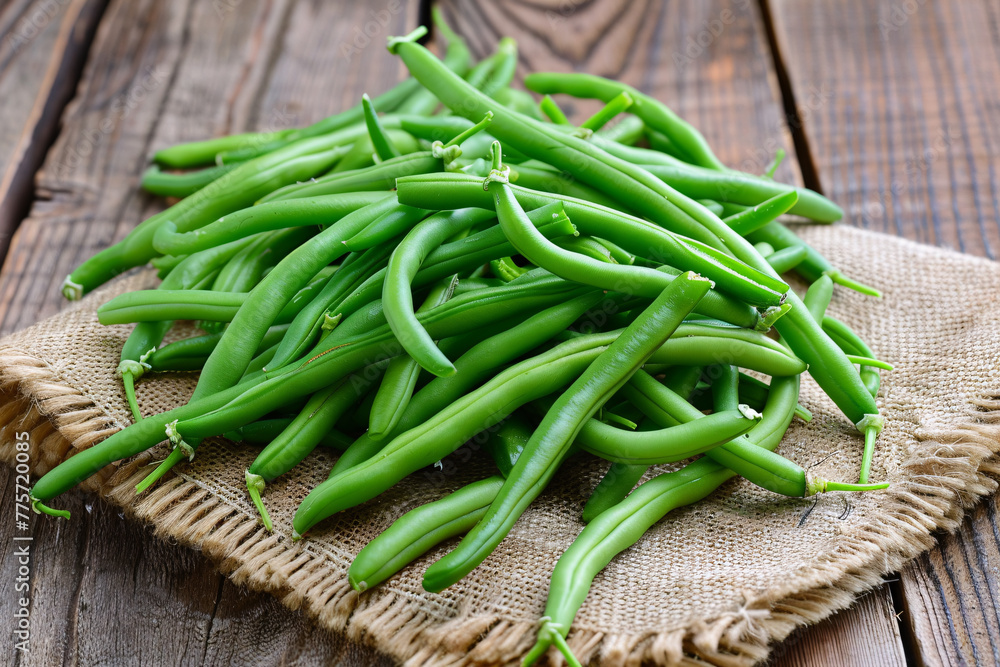 Fresh green beans on a wooden background and table, representing healthy organic produce from the market, ideal for vegetarian diets and nutrition
