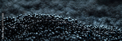 Dark Surface with Pile of Black Beads in Blurry Background, Abstract Texture or Background Concept