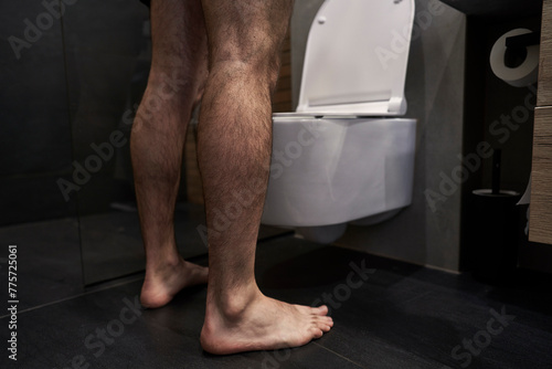 Canvas Print Unrecognizable man urinating in the toilet