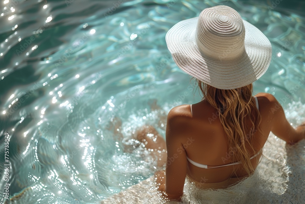 A young woman in a stylish hat enjoys summer by the pool, basking in relaxation