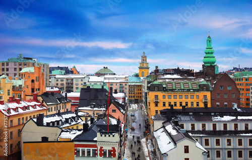 Beautiful cityscape - City museum  Church  traditional houses covered with snow and people go trough the street at the background of cloudy sky in Sodermalm  Stockholm  Sweden  Northern Europe