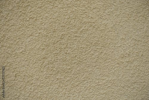 Close view of wall with coarse light beige roughcast finish