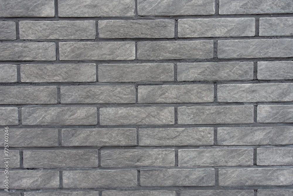 Texture of gray artificially aged brick veneer wall