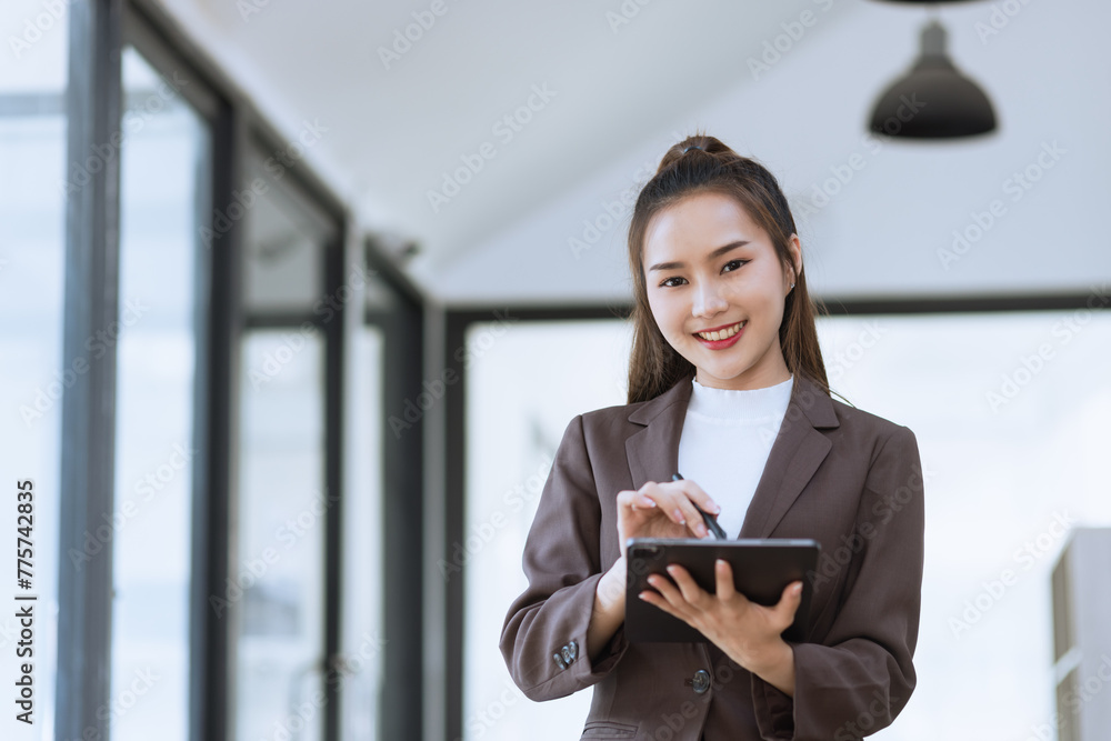 Asian businesswoman standing working with digital tablet in office. Asian businesswoman standing working with digital tablet in office.