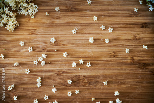 Cuadro en lienzo Top view of little white elderflowers on a wooden background
