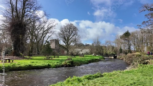 Blarney Castle and its serene Gardens, bathed in the soft light of a tranquil, picturesque morning under a clear blue sky, offer a captivating scene in Cork, Ireland