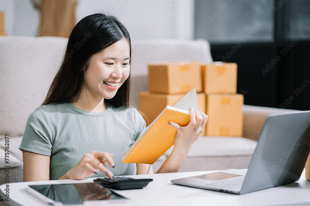 Young entrepreneur women working at home about online business. Business owner women using calculator and smart phone working at home. Young entrepreneur women working at home about online business. Business owner women using calculator and smart phone working at home.