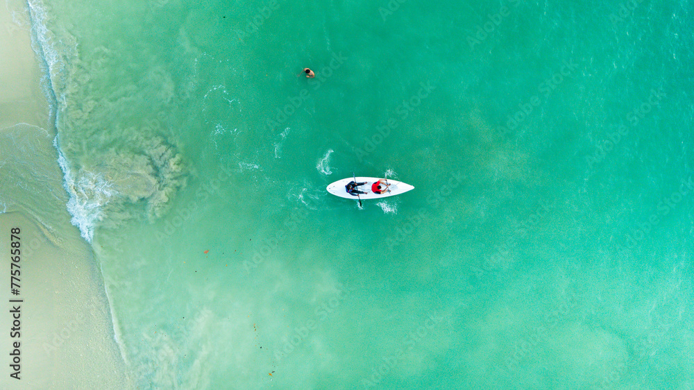 Top view of kayak boat oin shallow turquoise water of Kapas Island sea, Kuala Terengganu, Malaysia.
