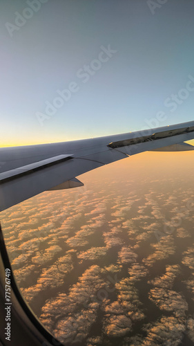 Wing of an aircraft during a flight at sunset horizon